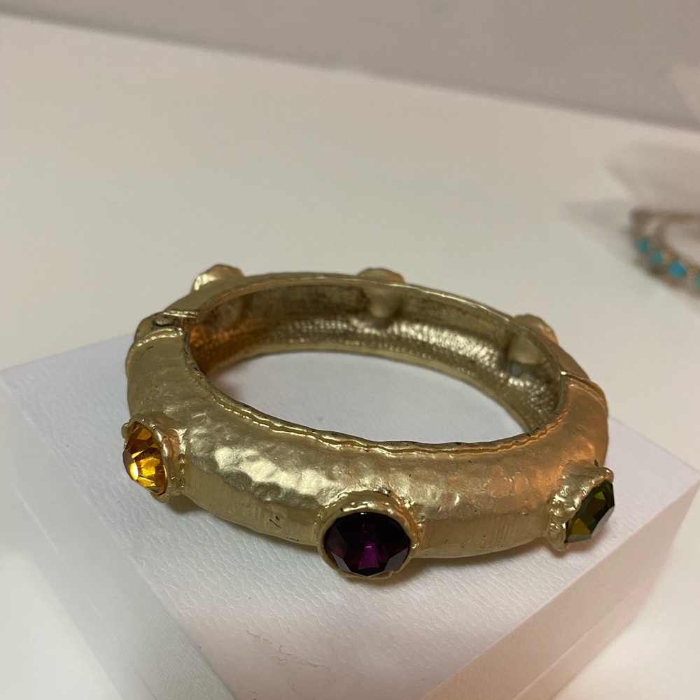goldtone statement bangle with 6 beautiful rhinestones. It opens